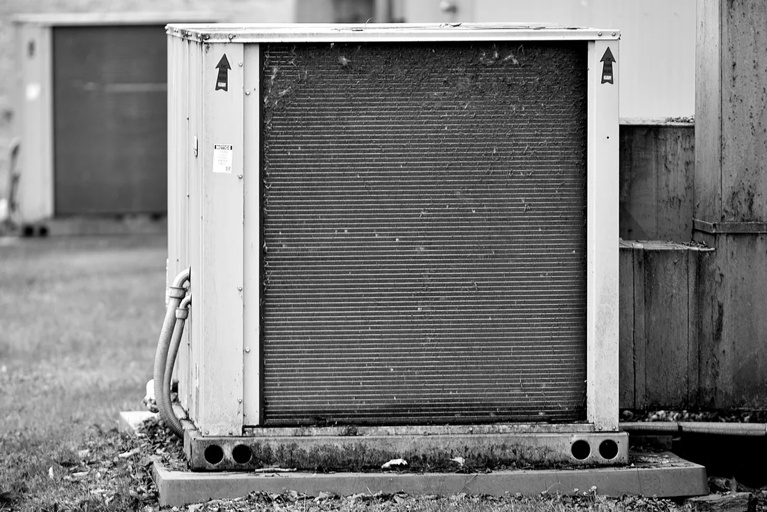 Technicien contrôlant une unité extérieure de climatisation bruyante
